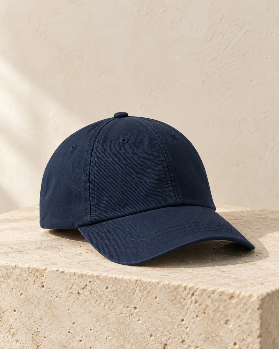 Plain navy baseball cap on a stone plinth, illustrative style reference